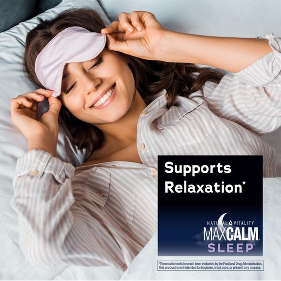 View 5 A smiling woman in bed adjusts her sleep mask alongside a graphic for Natural Vitality MaxCalm Sleep, stating 'Supports Relaxation*'.