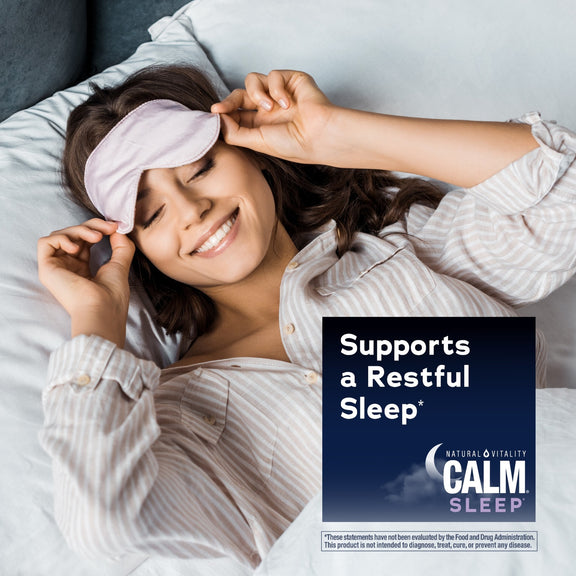 View 5 Young woman smiling in bed, adjusting a sleep mask, with a graphic for Natural Vitality Calm Sleep.
